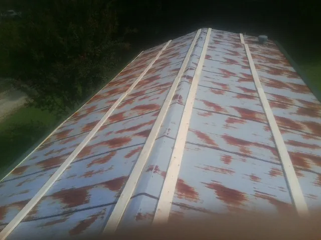 Rusted metal roof panels with new wood purlins before replacement — Storm Damage Roof Repair in Early Branch by Roofing Brothers