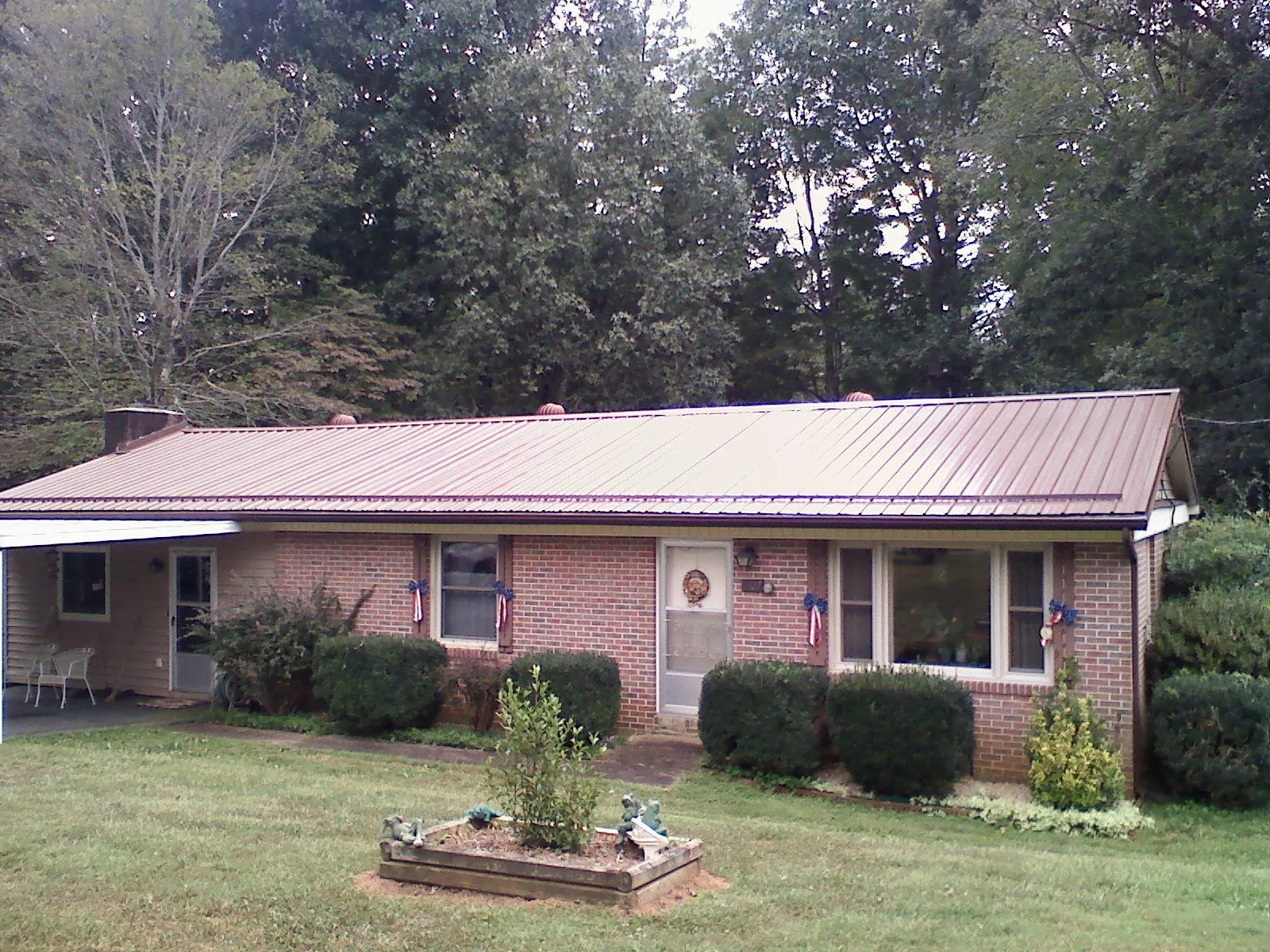 Bronze metal roof on a brick ranch home with a carport in Early Branch