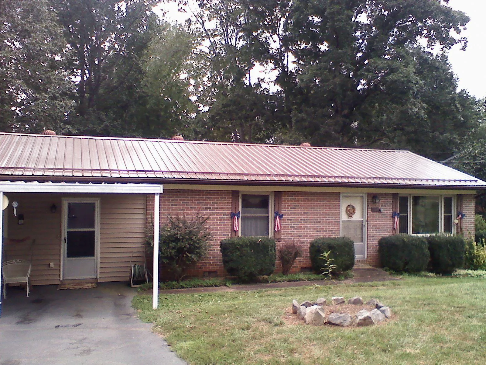 Bronze metal roof and carport on a brick ranch home — Roof Repair work by our crew in Early Branch